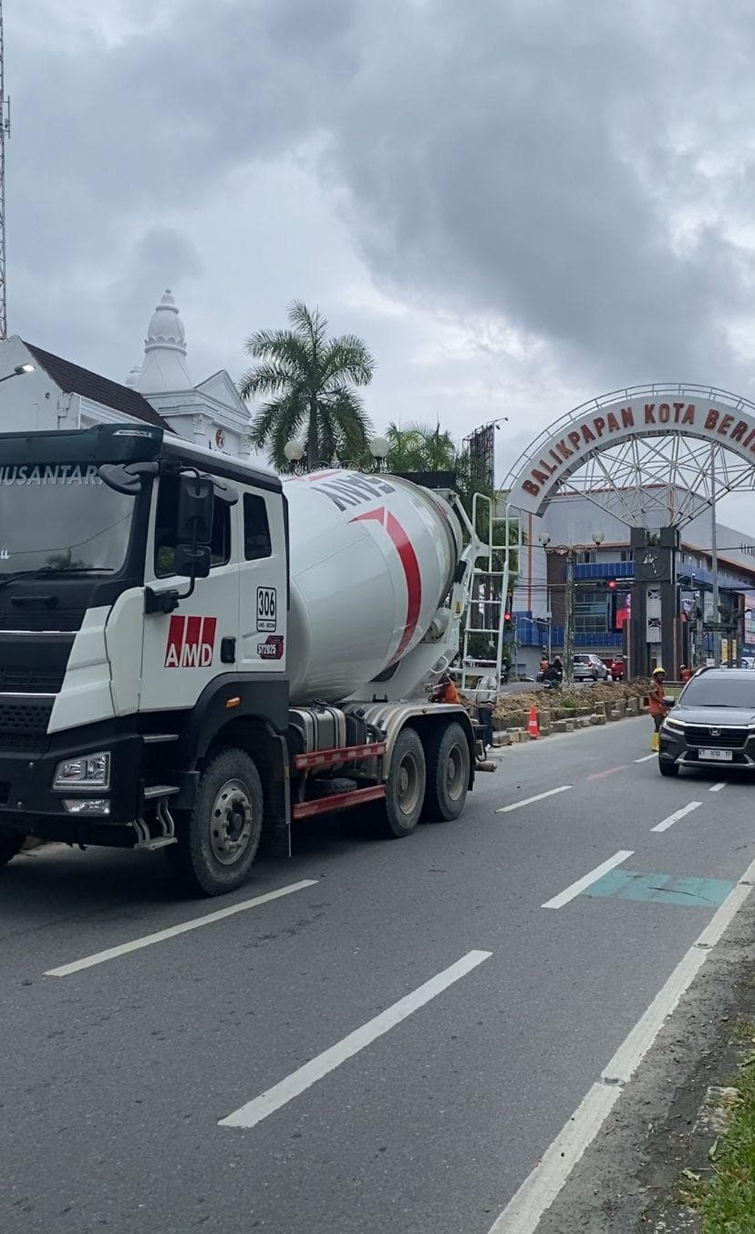 Truk molen putih melintas di jalan raya Balikpapan dekat gapura selamat datang Kota Beriman.